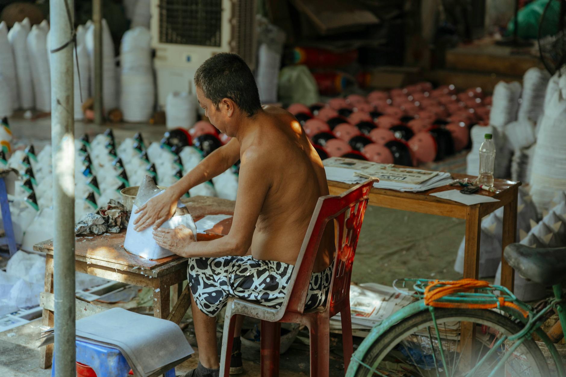 Artisans hand-painting paper umbrellas at a workshop demonstration booth during the festival