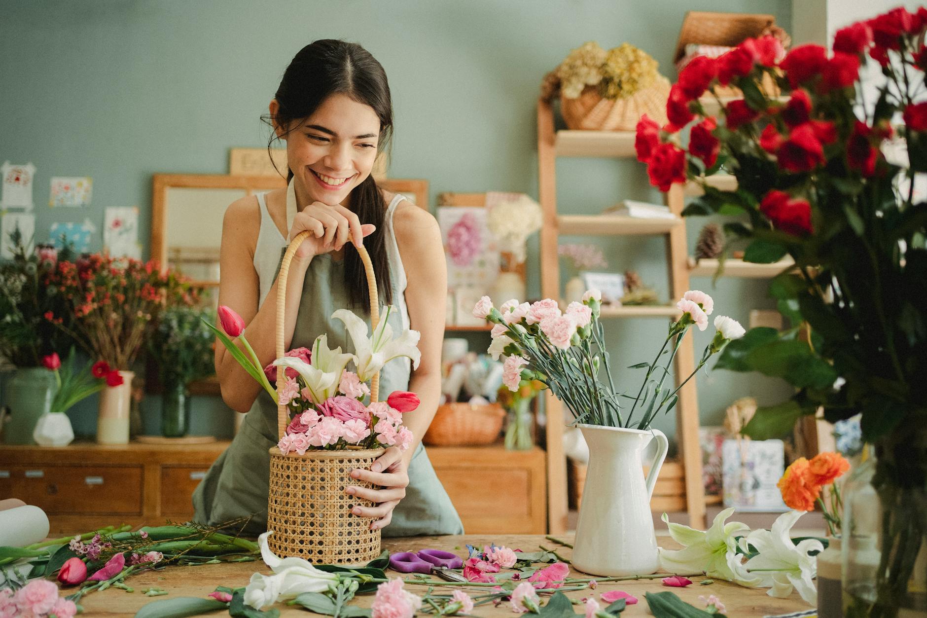 A florist carefully placing orchids into an elaborate competition arrangement at Nong Bua Hat