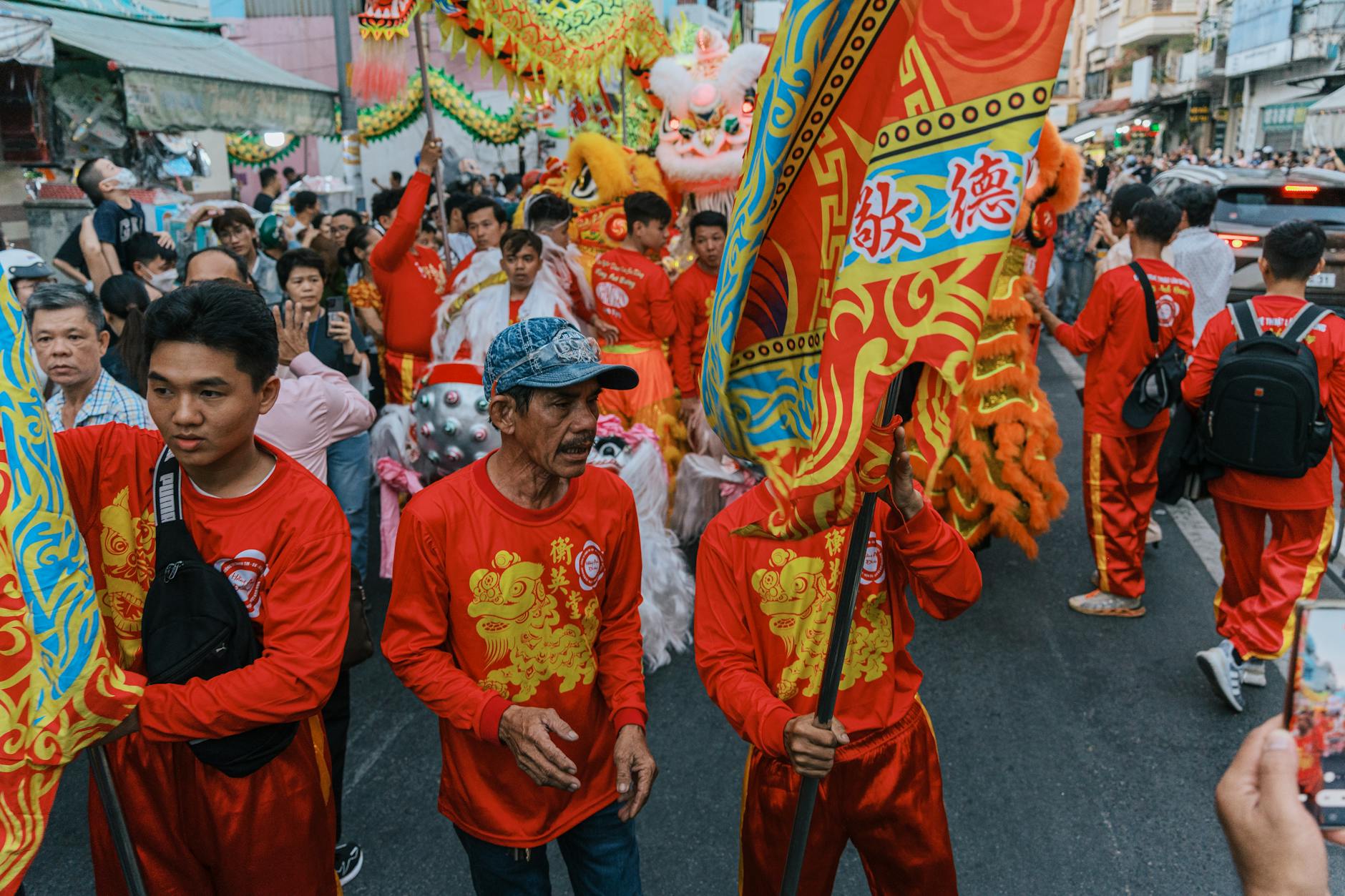 Lion dance performers leaping between poles in front of a Chinese temple in Bangkok during Lunar New Year