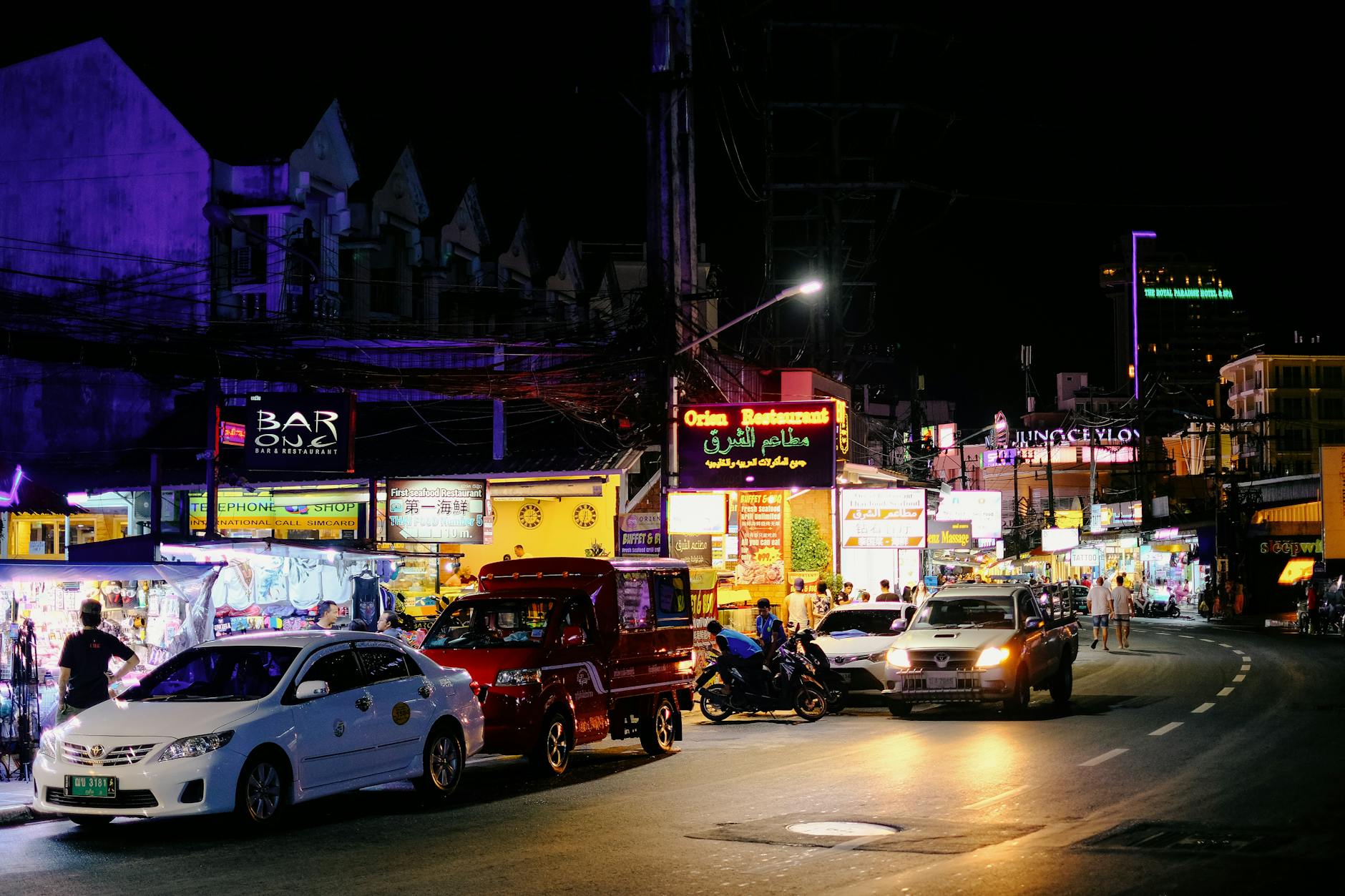 Colorful krathongs made from banana leaves and flowers displayed at a night market before the festival