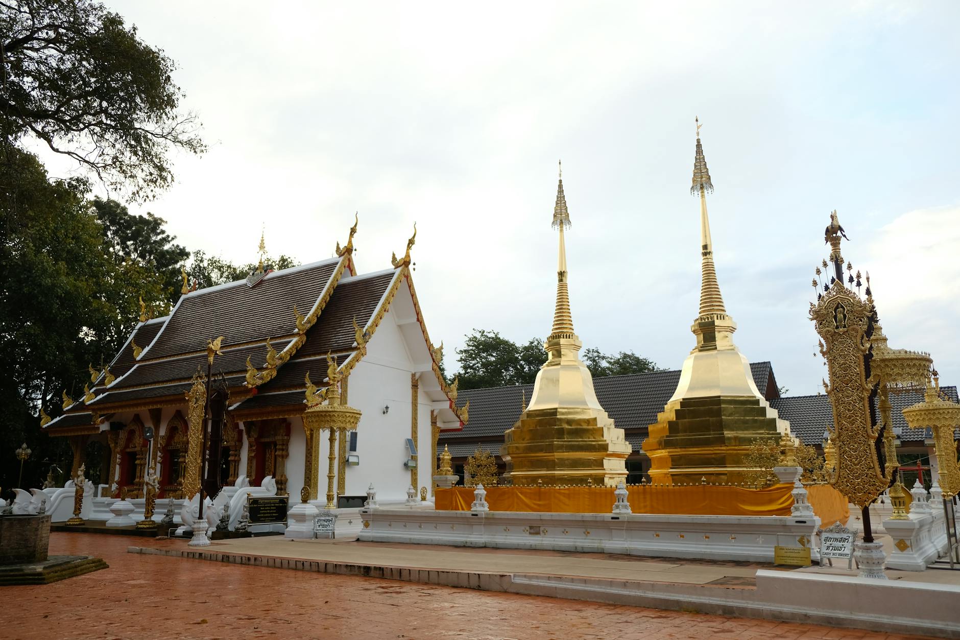 Tourists dressed in modest attire walking respectfully during a candlelight ceremony at a Thai temple