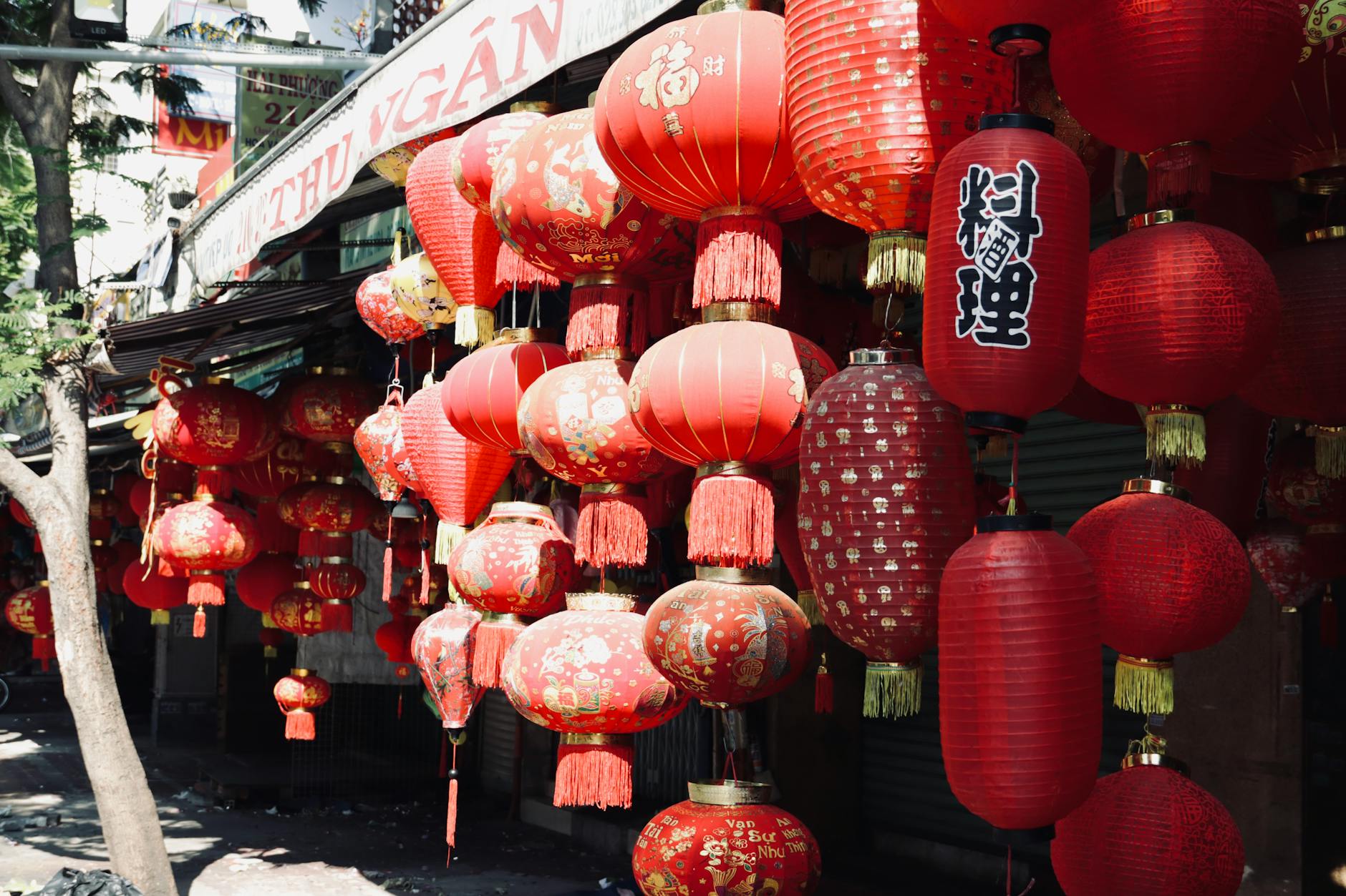 Mooncakes and Chinese tea arranged on a wooden table with a red lantern backdrop in Bangkok's Chinatown