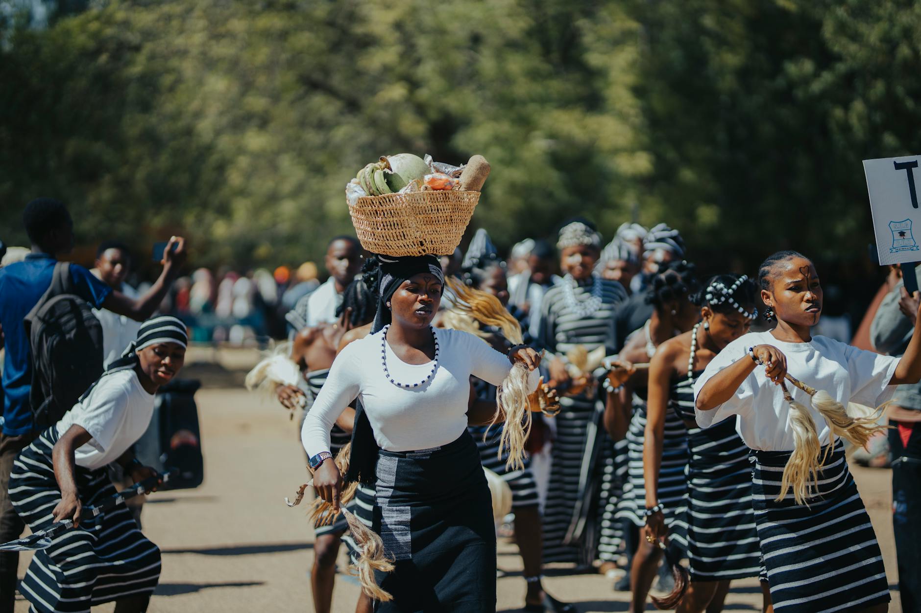 Poy Sang Long boys being carried on the shoulders of adult relatives through crowded streets with traditional Shan musicians ahead