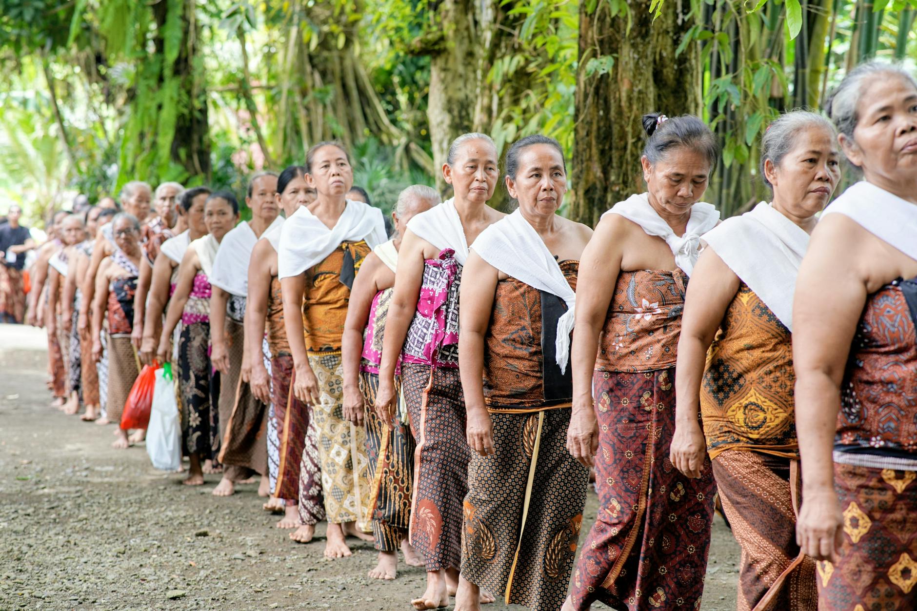 Shan women in traditional embroidered clothing walking alongside a Poy Sang Long procession in Mae Hong Son