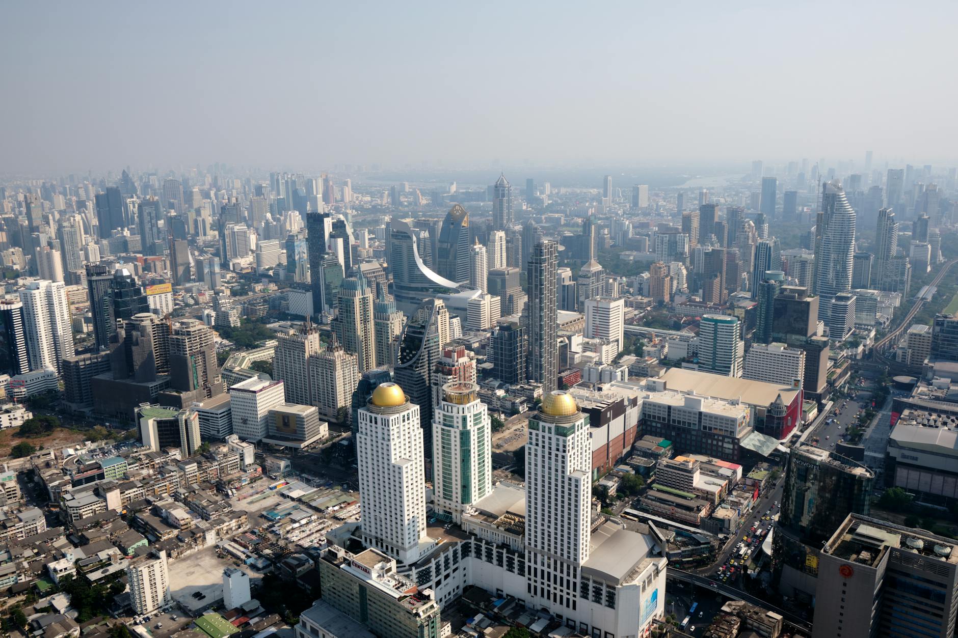Aerial view of Sanam Luang with the Grand Palace in the background, crowds gathered for the Royal Ploughing Ceremony