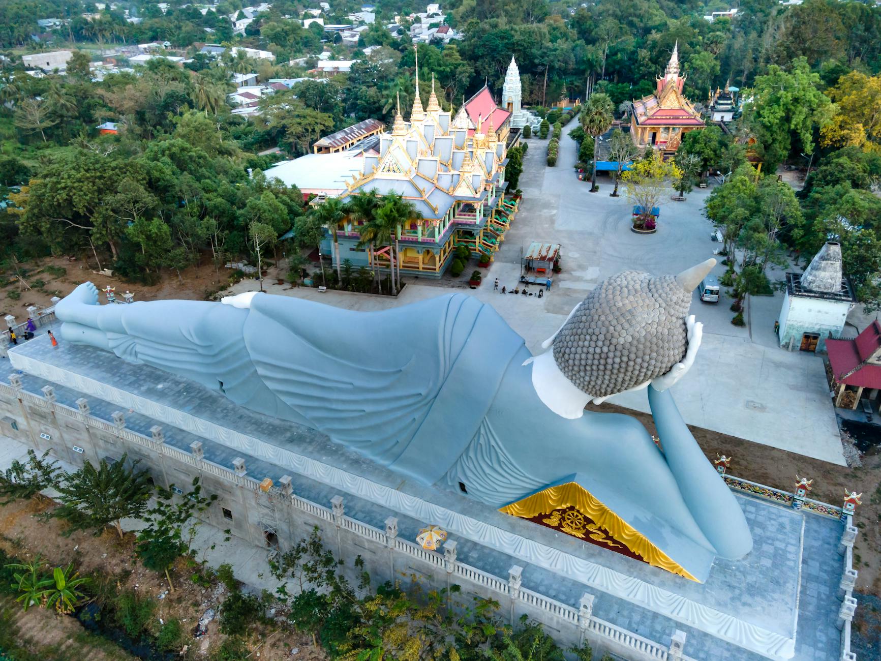 People pouring water over a Buddha statue during Songkran at a Thai temple