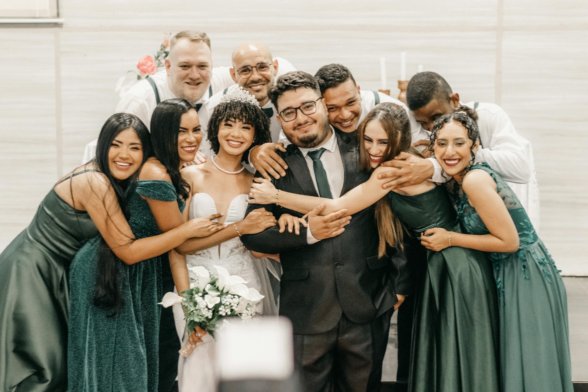 A lineup of couples in wedding attire posing together after completing the underwater ceremony, still in their dive gear