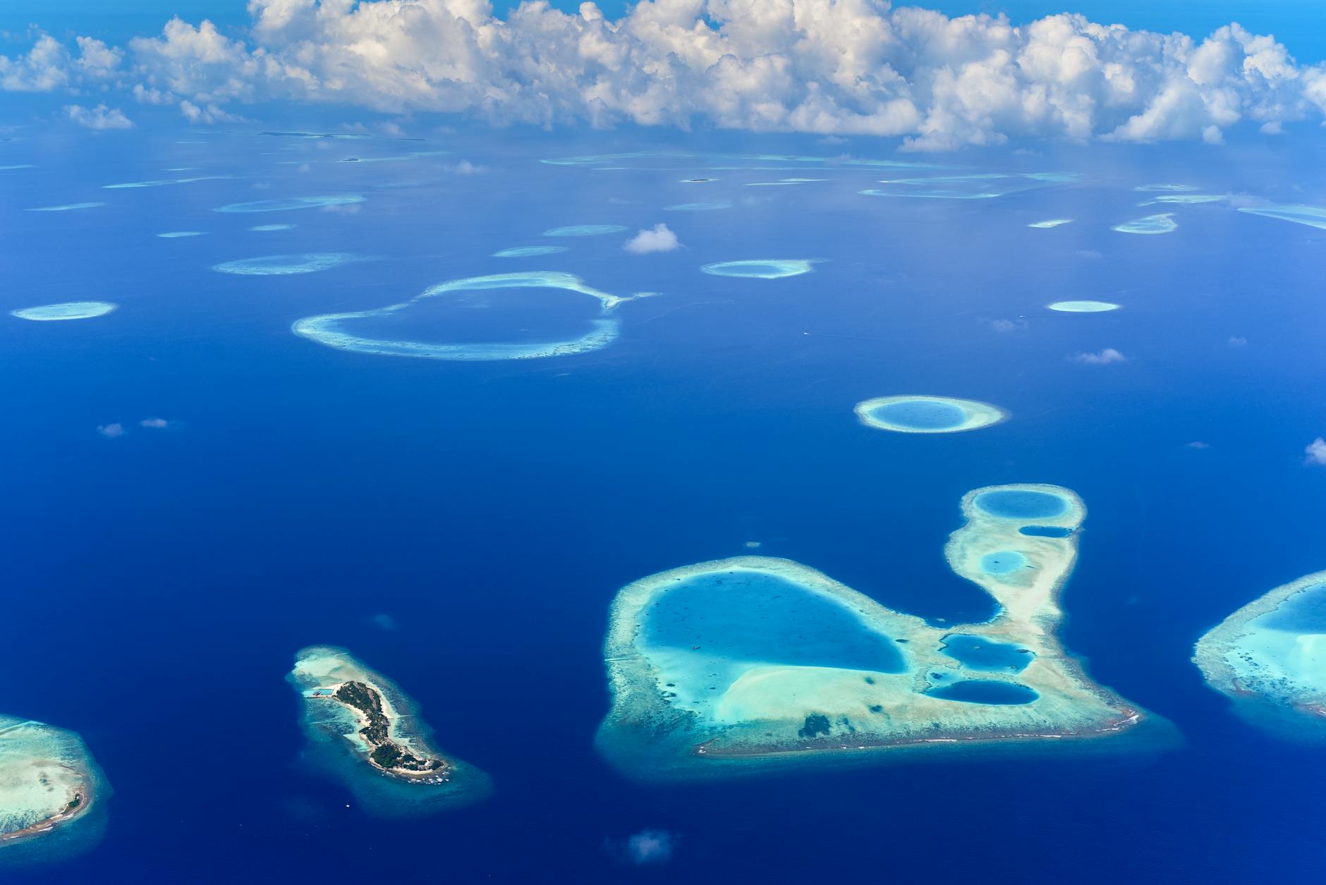 Aerial view of Koh Kradan in Trang, showing the island's white sand beach surrounded by vivid turquoise water and coral reefs