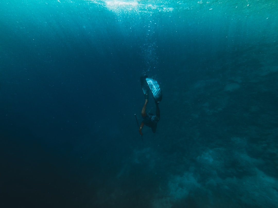 Couple in wedding attire diving underwater during Trang Underwater Wedding ceremony