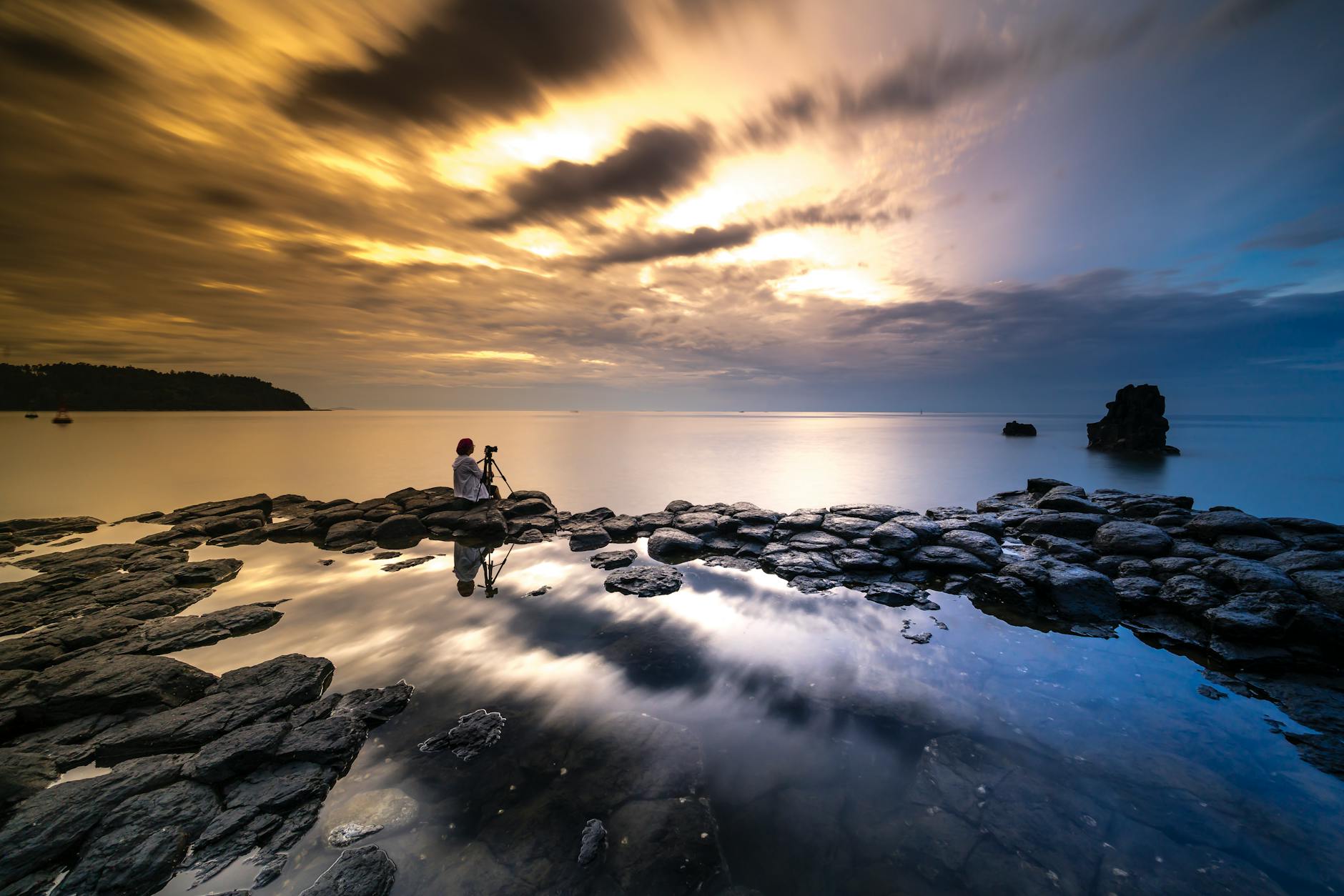 Photographer capturing long-exposure lantern trails at Yi Peng with tripod at the Ping River