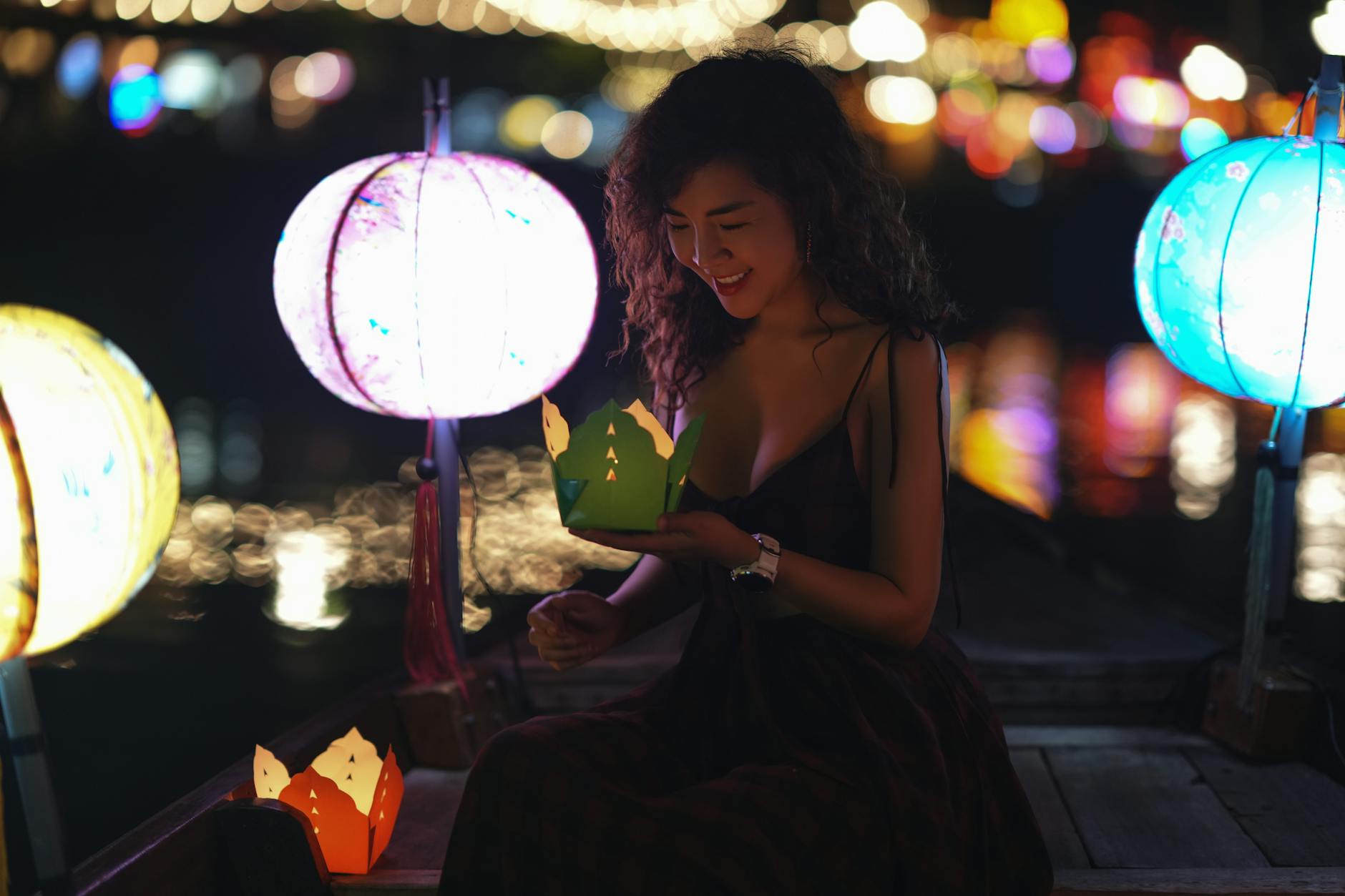 A traveler releasing a khom loy lantern with closed eyes and a wish during Yi Peng
